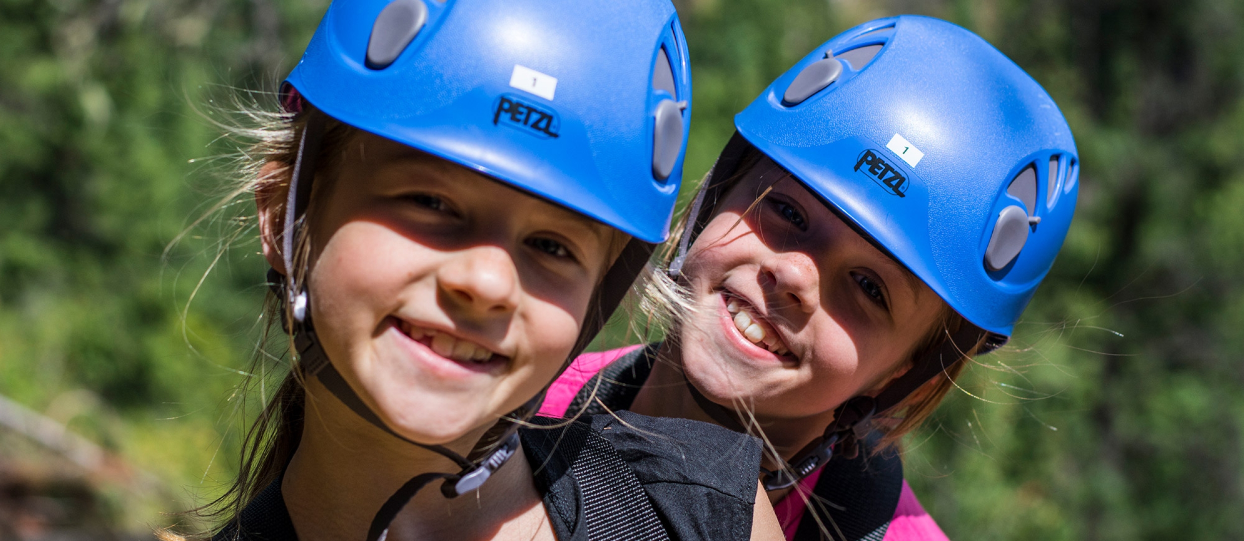 Two children with blue helmets on Kokanee Mountain Zipline near Nelson BC