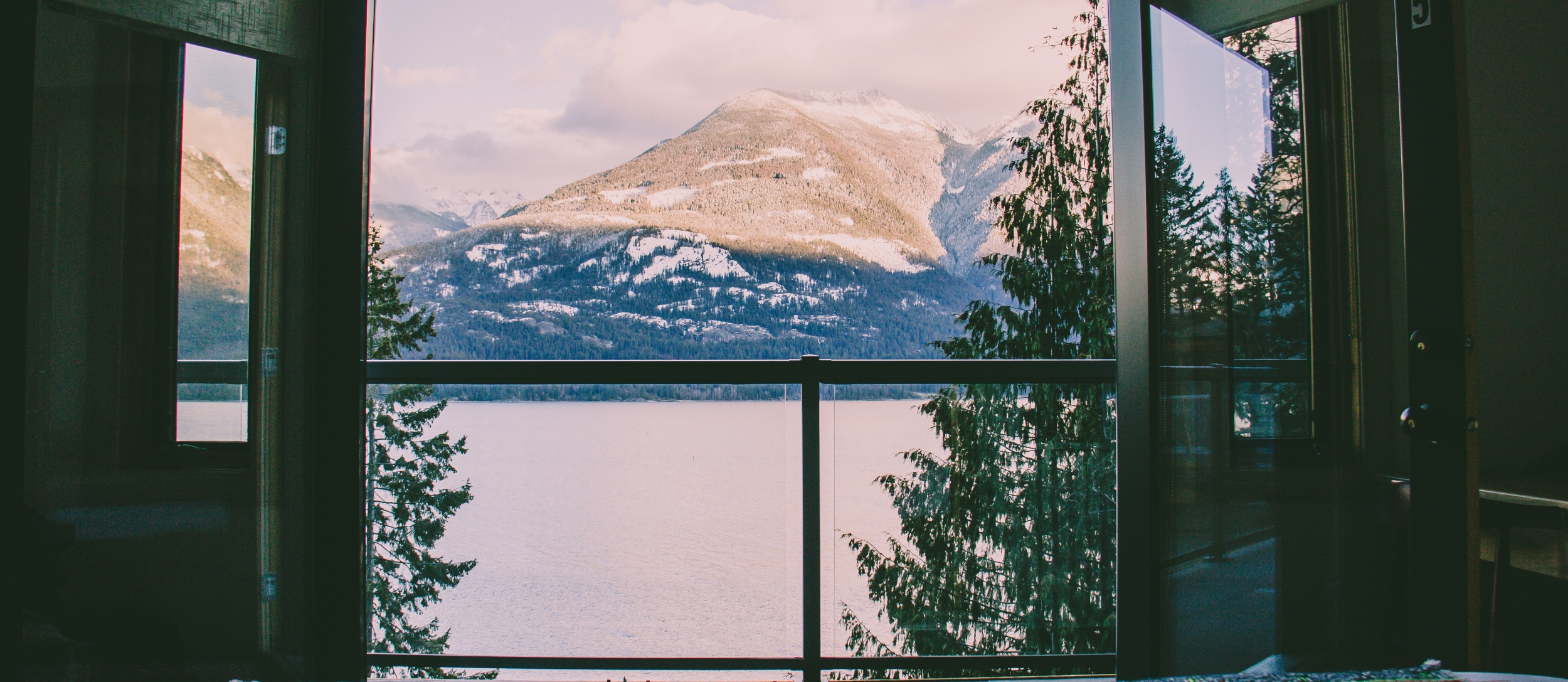 View of snowy mountains from inside accomodation.