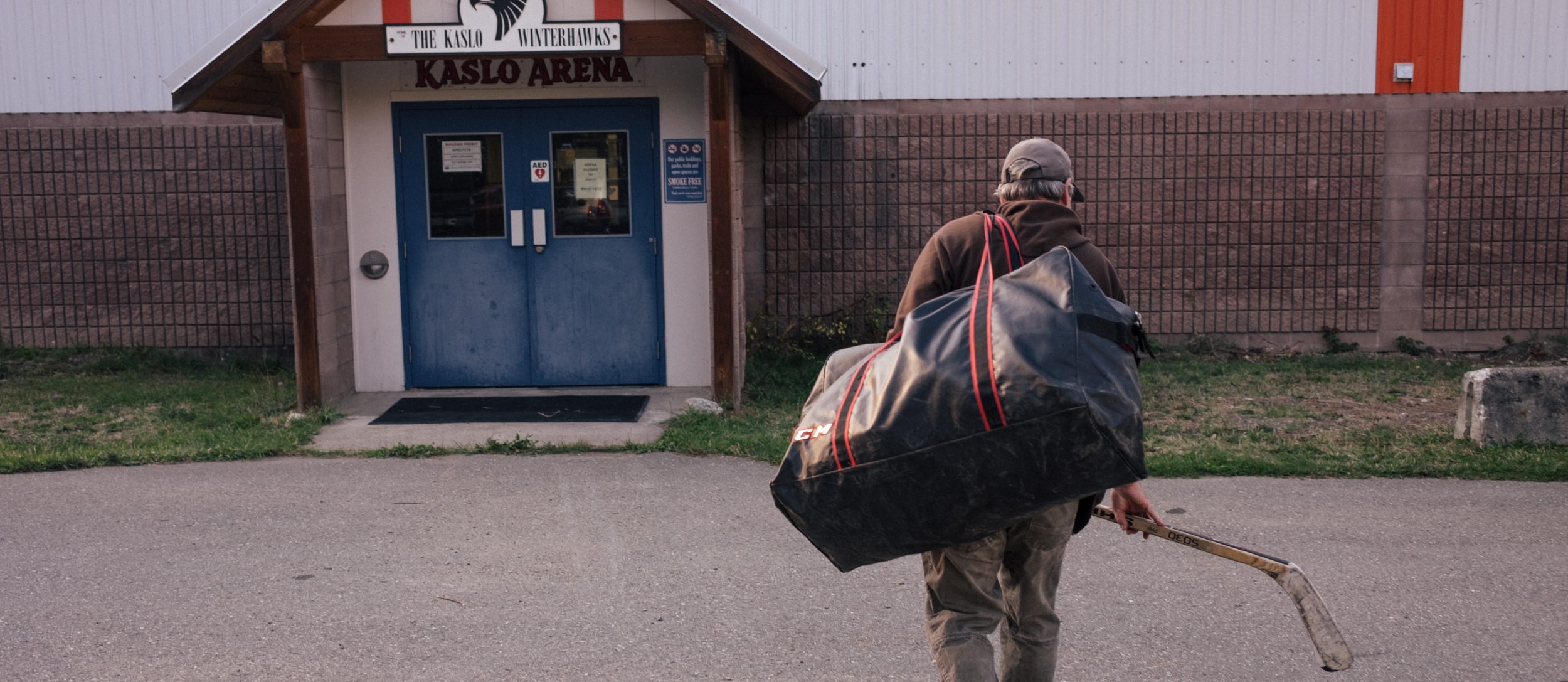 Man walking into Kaslo Hockey Arena