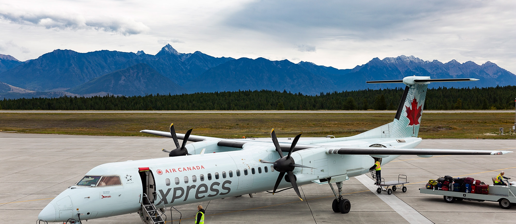 A plane with mountains in the background Canadian Rockies International Airport in Cranbrook, BC