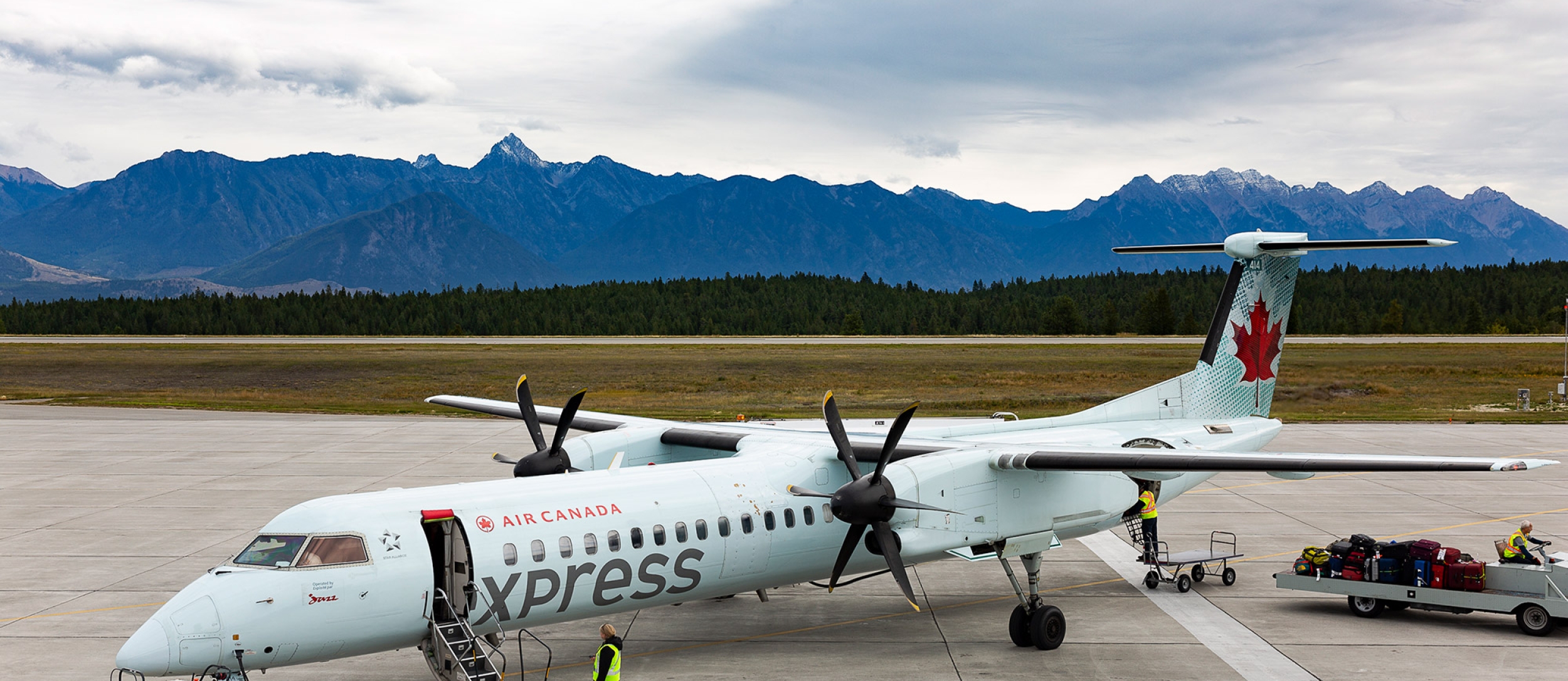 A plane with mountains in the background Canadian Rockies International Airport in Cranbrook, BC