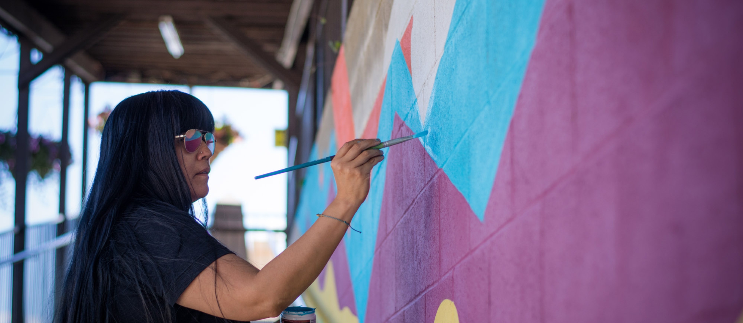An artist painting a colourful mural at Ainsworth Hot Springs Resort