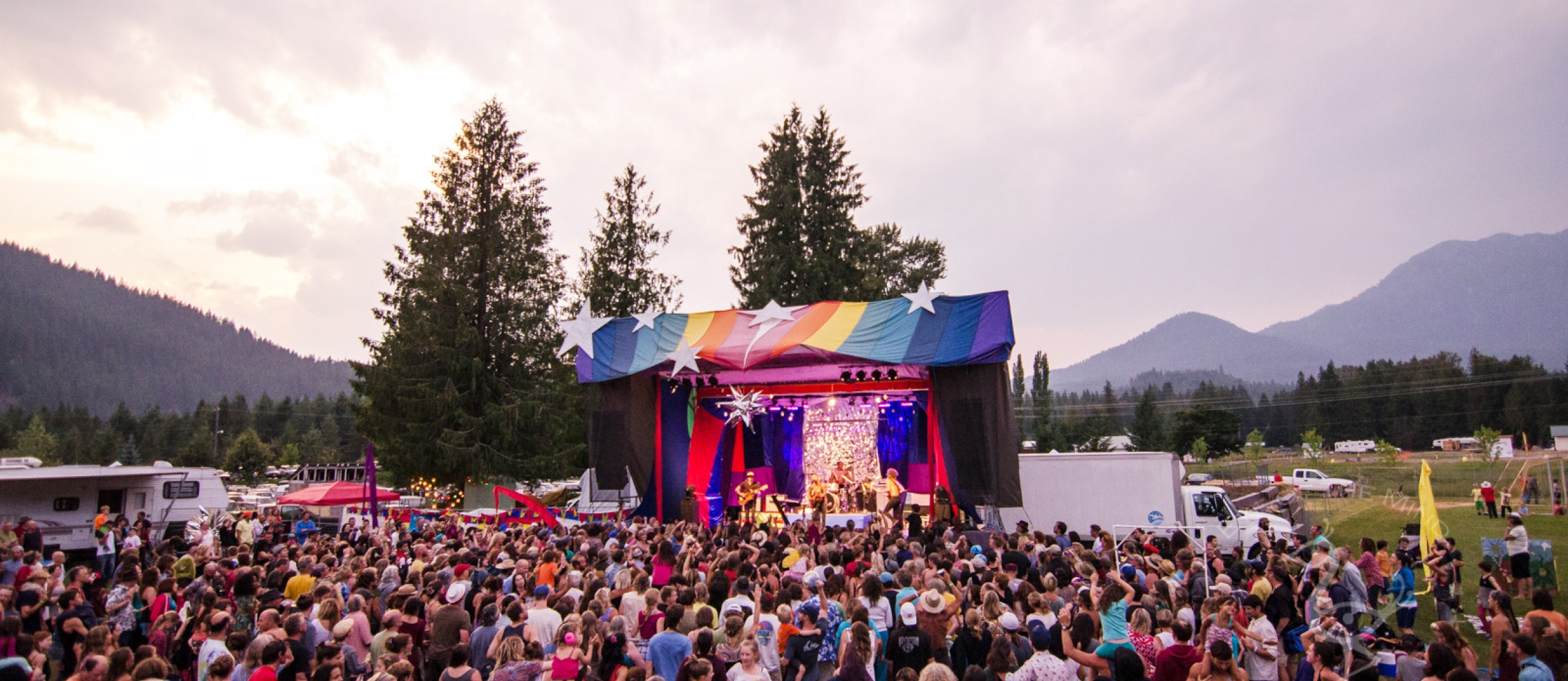 A crowd in front on a colourful stage at Starbelly Jam Music Festival in Crawford Bay, ,BC