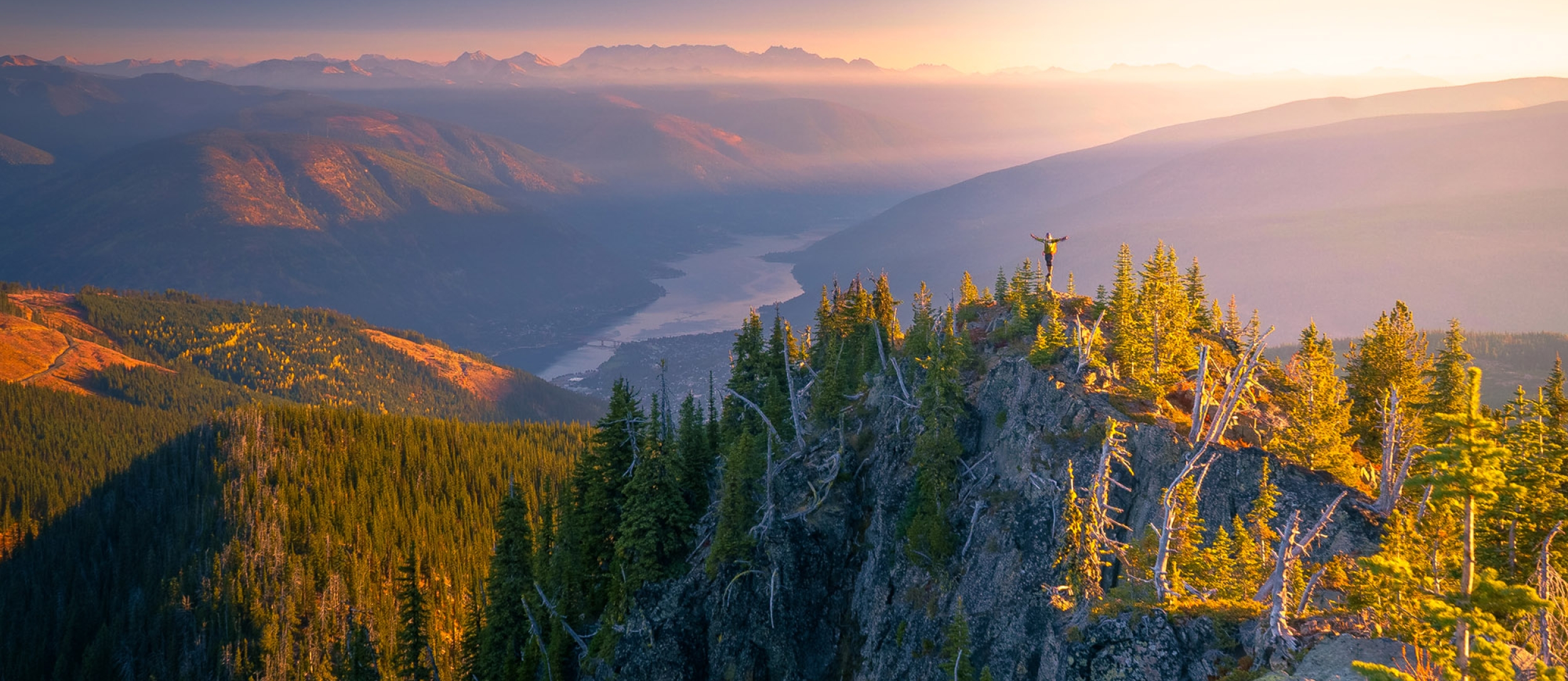 A hiker on Toad Peak overlooking Kootenay Lake in Nelson, BC.