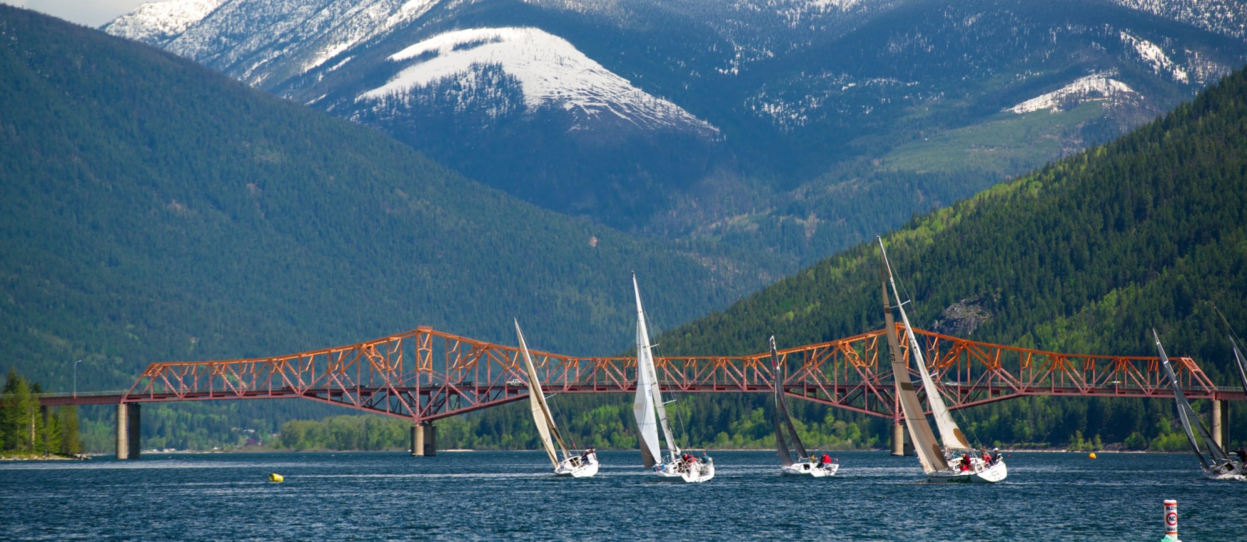 Sailboats on Kootenay Lake with the Big Orange Bridge in the background. 