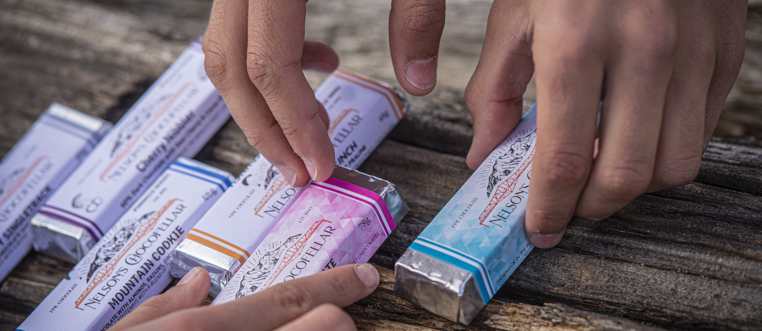 Hands reaching out for Chocofellar chocolate bars in Nelson BC.