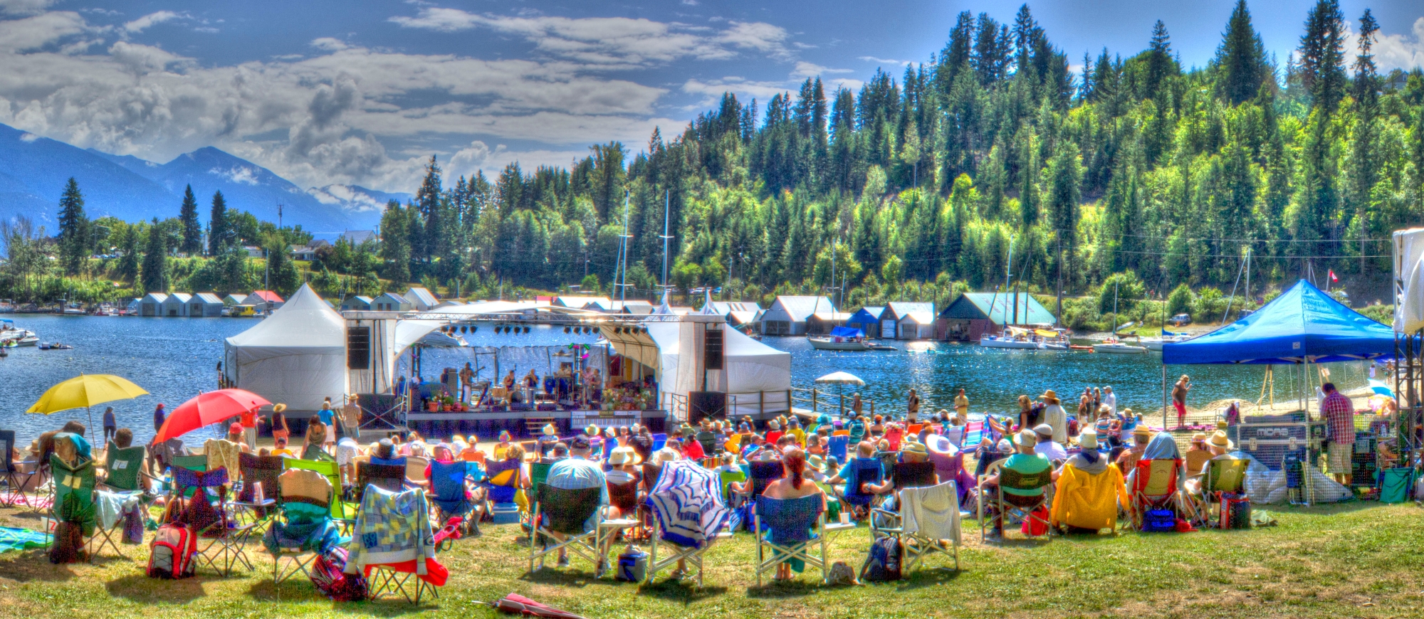 Audience enjoying Kaslo jazz festival stage with mountains and lake in the background