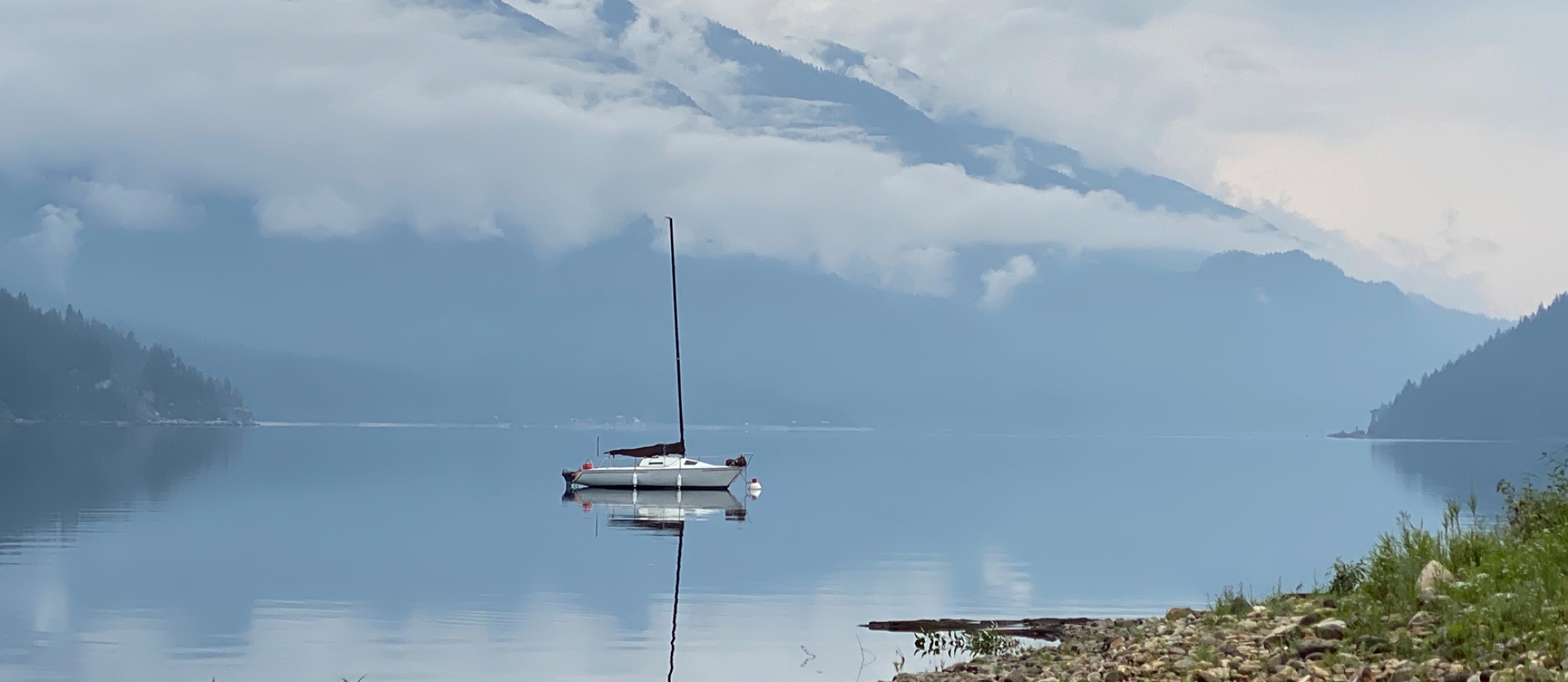 Boat on Kootenay Lake with low hanging clouds.