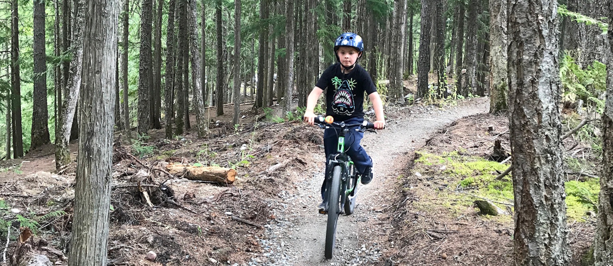 A boy riding his bike at the Kaslo Pump Track.