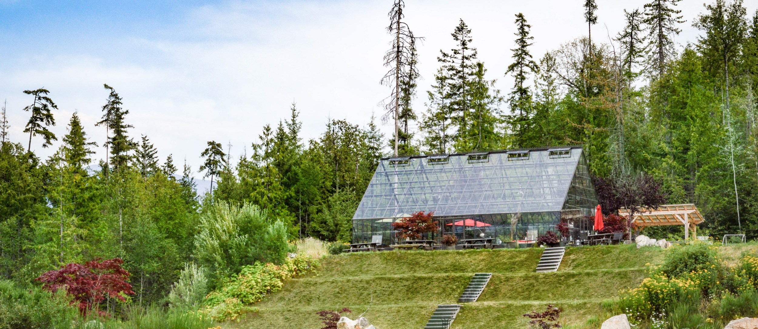 Kootenay Lake Village in the summertime surrounded by trees and flowers.