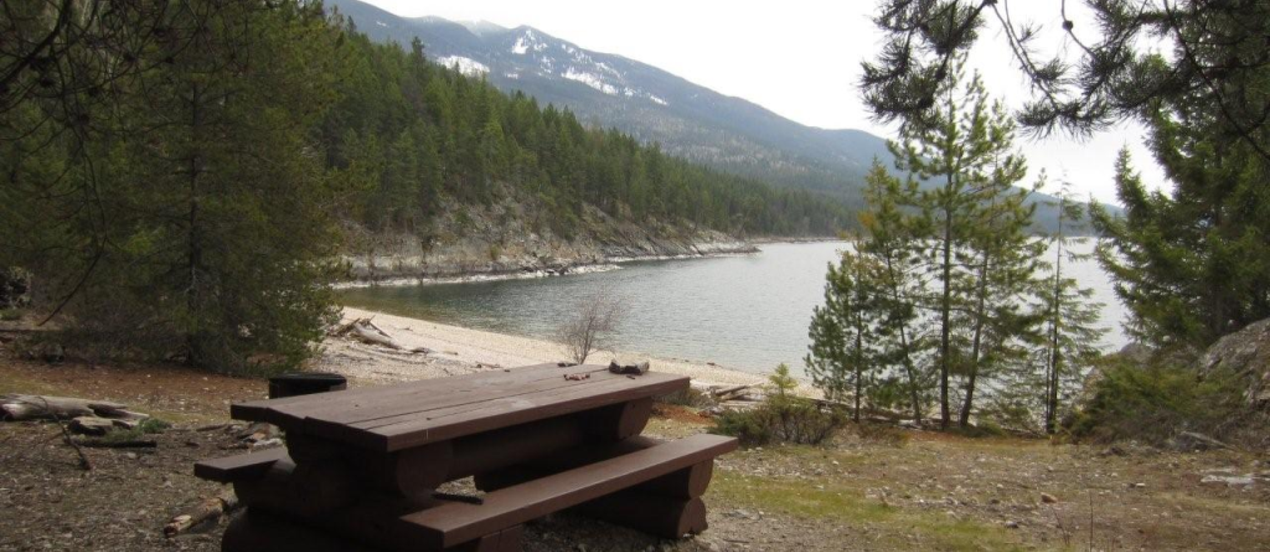 Picnic table and beach at Pebble Beach Rec Site near Crawford Bay