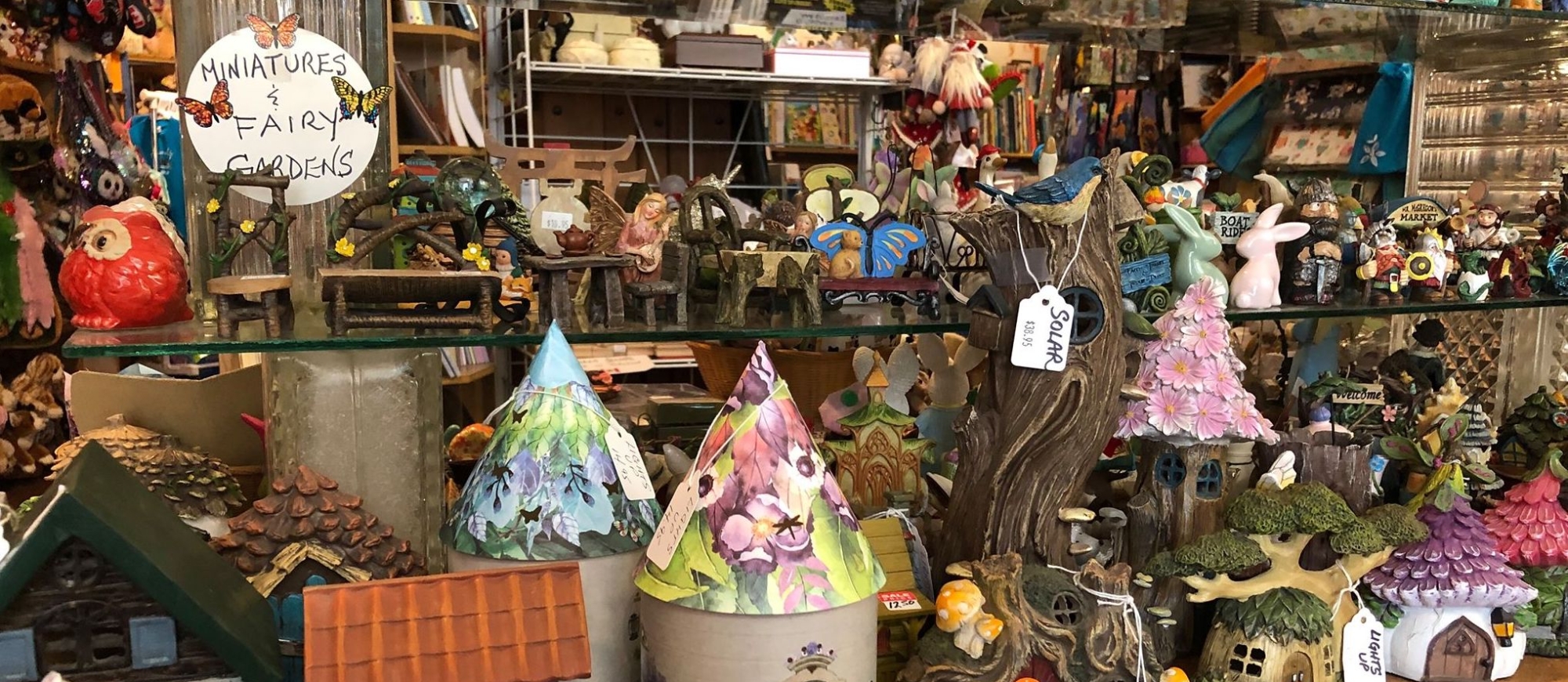 Trinkets, decorations and statues on a shelf at Through The Looking Glass