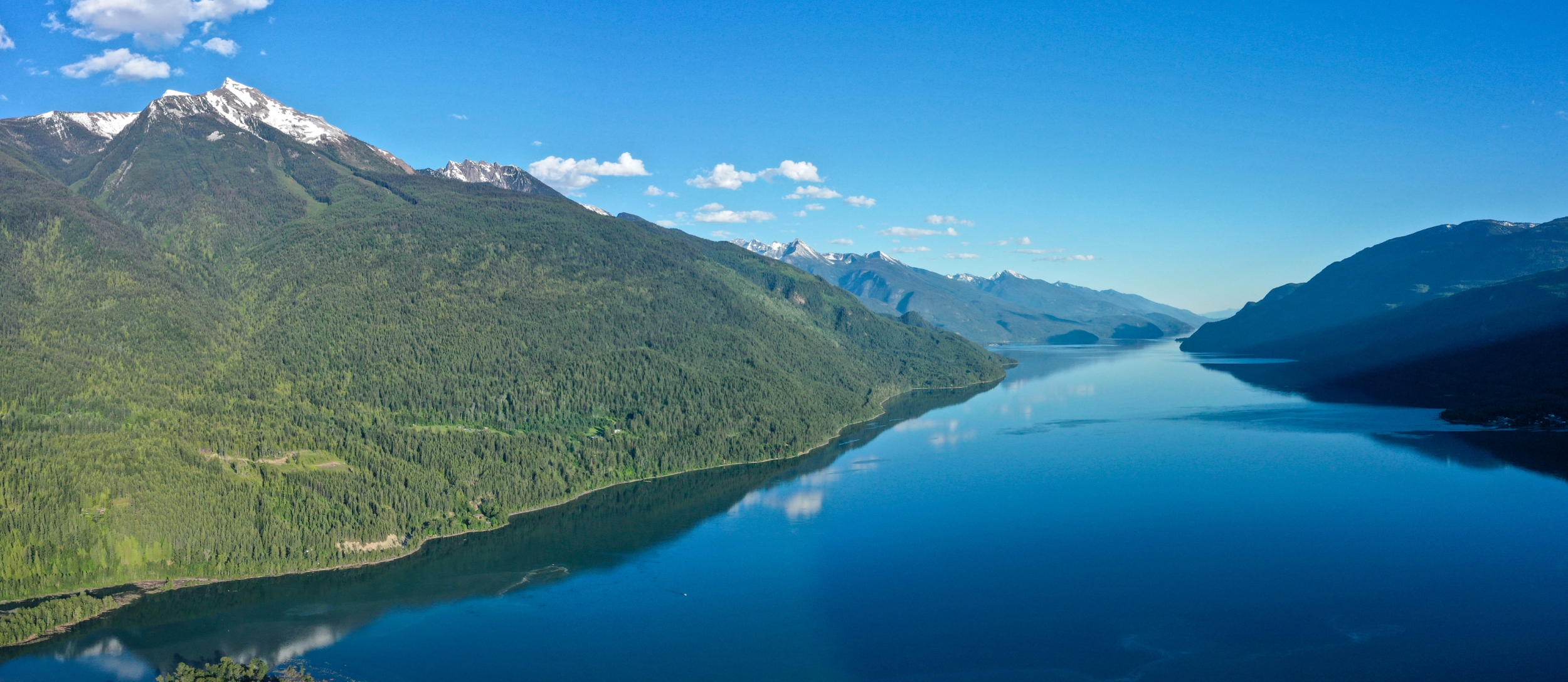 Aerial view of Kootenay Lake and mountains covered with green trees