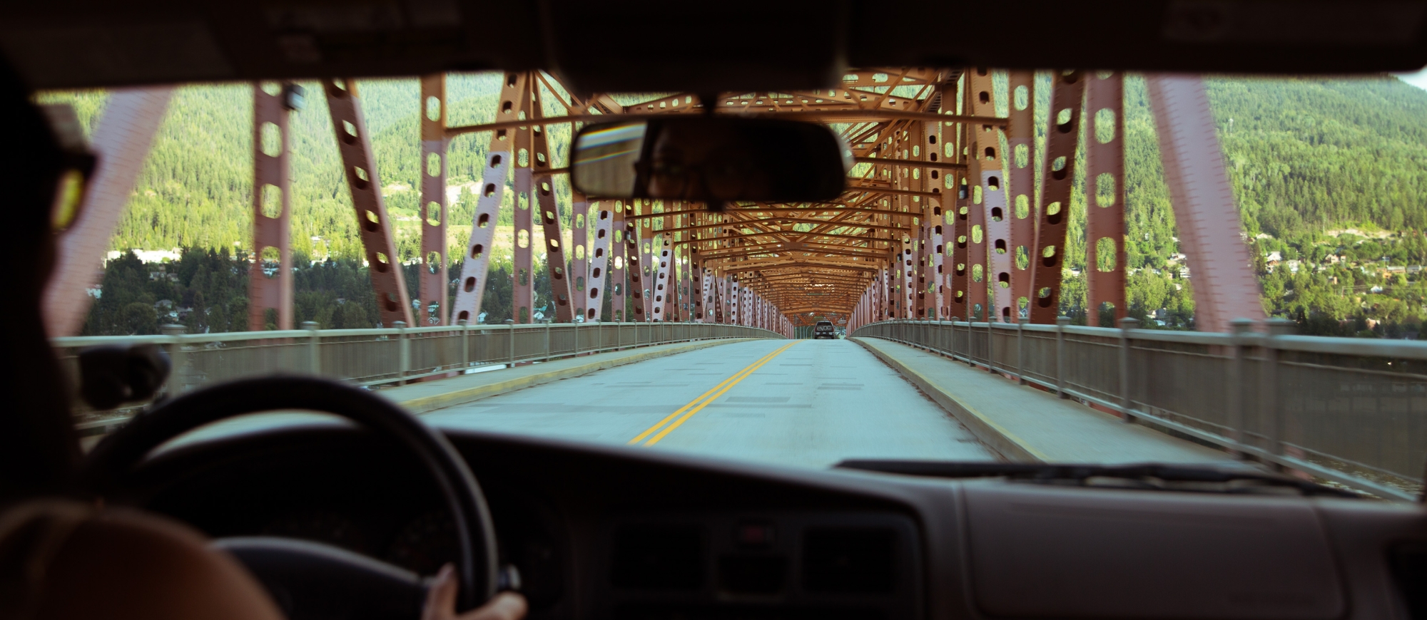 Girl driving over the big orange bridge in Nelson