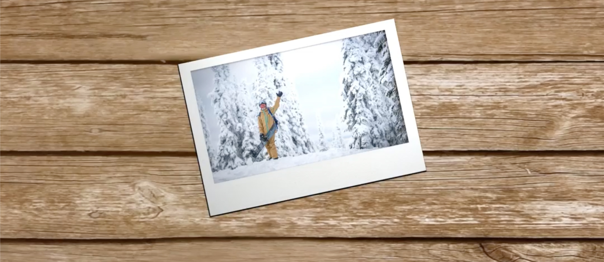 Photo lying on a wooden desk at an angle, of man on snowy day waving at camera