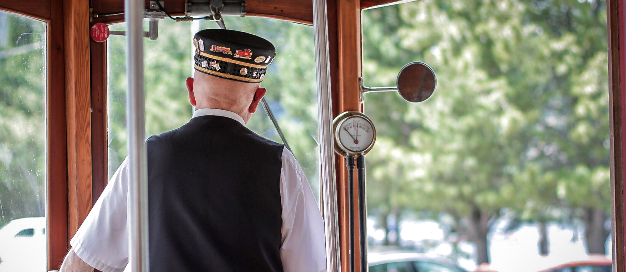 Looking through the front windows of Streetcar #23 with the driver in uniform in the foreground.