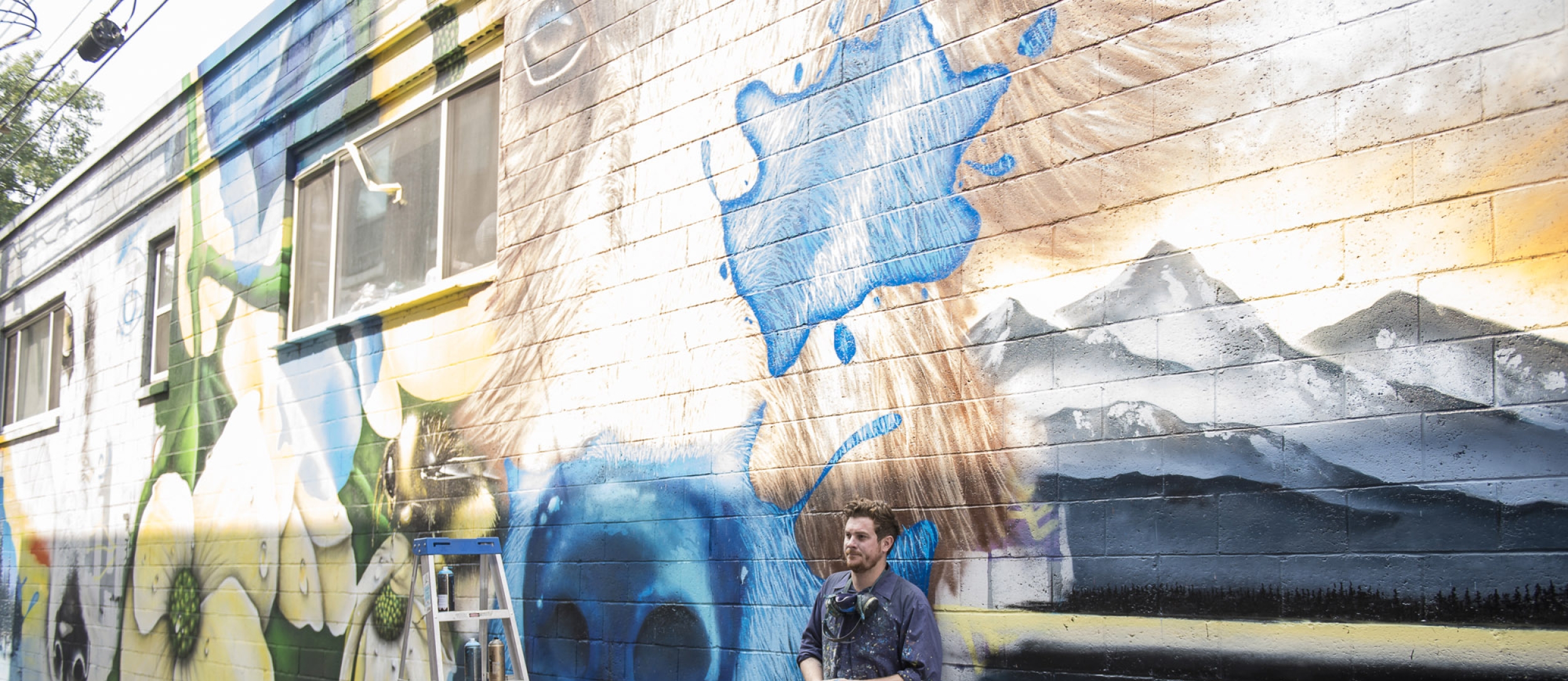 Artist Jerome Davenport stands in front of his mural at the 2018 Nelson International Mural Festival.