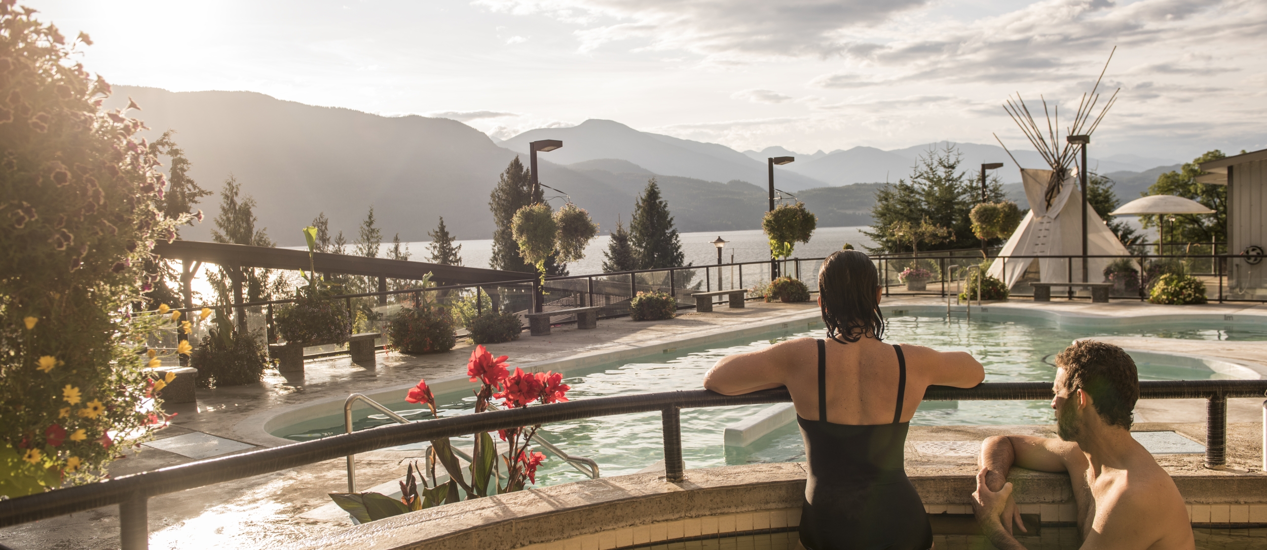 Bathers enjoying swimming at Ainsworth Hot Springs Resort with a view of Kootenay Lake.