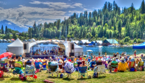 Audience enjoying Kaslo jazz festival stage with mountains and lake in the background