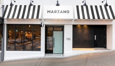 The outside of the Marzano restaurant showcasing white and black awnings