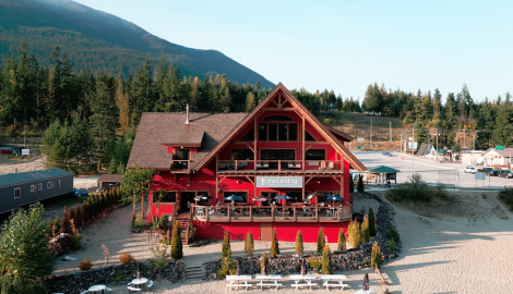 The big, red building of The Landing with people dining on their patio.
