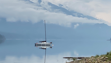 Boat on Kootenay Lake with low hanging clouds.