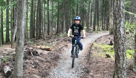 A boy riding his bike at the Kaslo Pump Track.