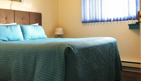 a bed with blue sheets in a room at Kokanee Glacier Resort