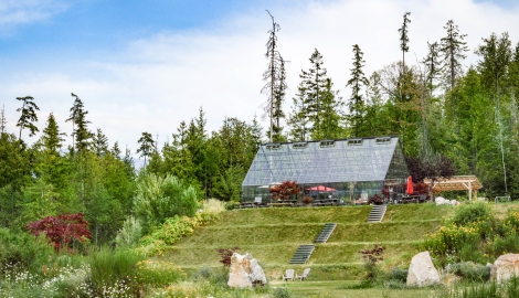 Kootenay Lake Village in the summertime surrounded by trees and flowers.