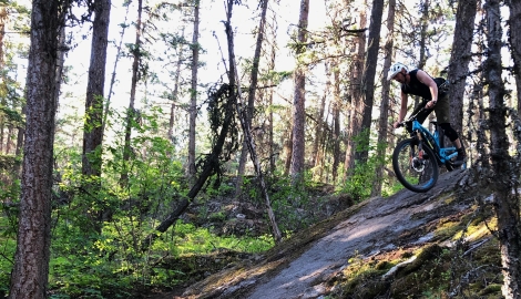 Person riding a mountain bike down a rock slab.