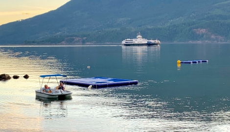 Kids on a pedal boat at the beach.